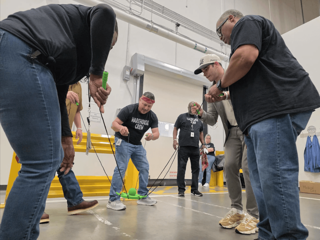 A team working through a hands-on training activity on the floor
